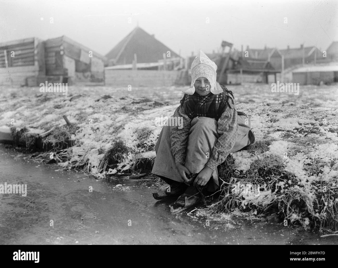A Dutch Idyll A charming photograph of a jolly little Dutch girl preparing for a skate in North Holland 10 December 1921 Stock Photo