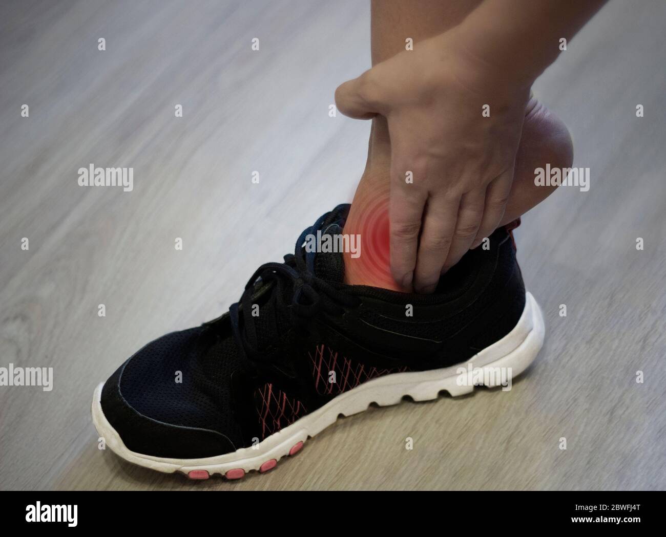 Young woman massaging her painful foot from exercising and running