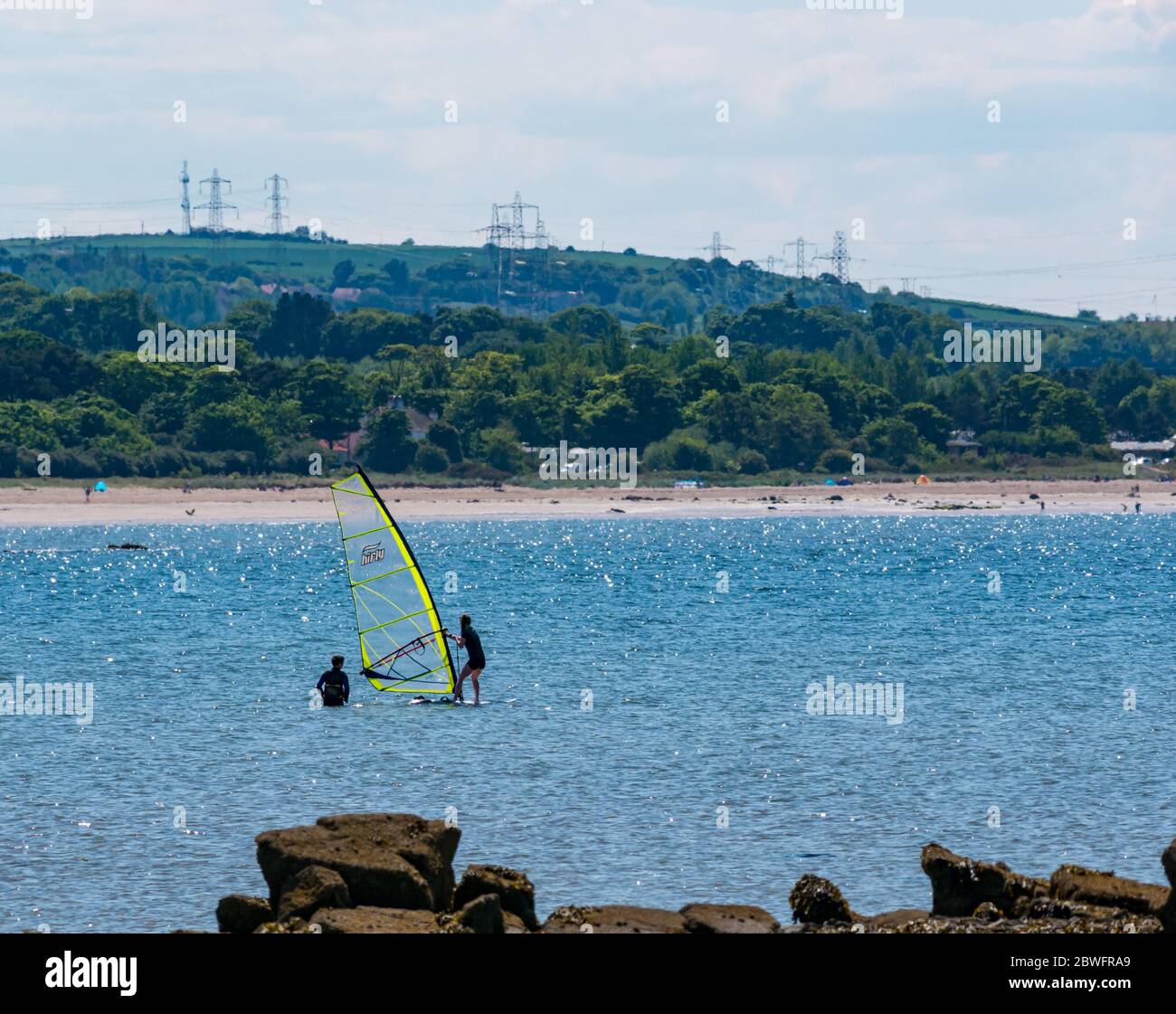 Longniddry Bents, East Lothian, Scotland, United Kingdom, 1st June 2020. UK Weather: hot sunshine at the beach brings people out despite the public car park still being closed during the Covid-19 pandemic lockdown. A windsurfing lesson in the Firth of Forth Stock Photo