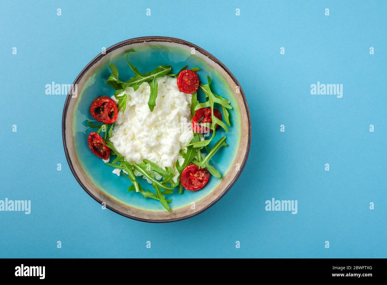 Breakfast bowl with eggs, scrambled egg on blue background Stock Photo