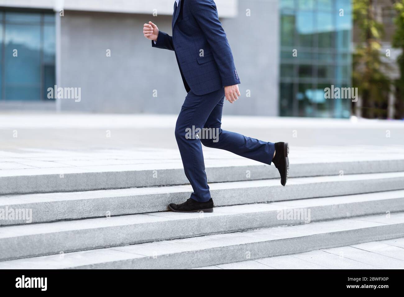 Cropped view of businessman in formal suit running up stairs near office  building Stock Photo - Alamy