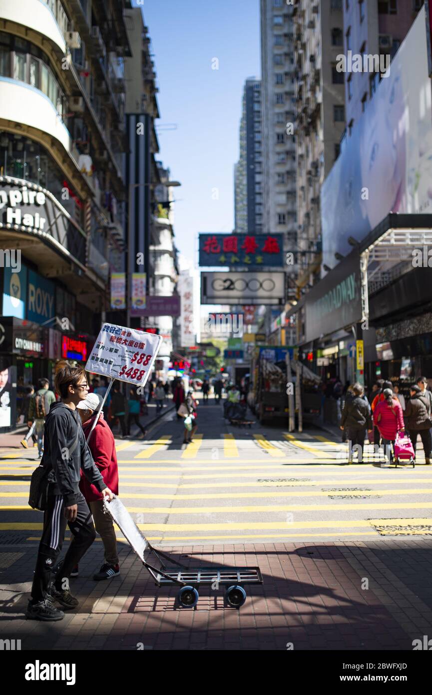 Daily life on the streets of Hong Kong with people walking and shopping during a sunny day. Hong Kong is a special Stock Photo
