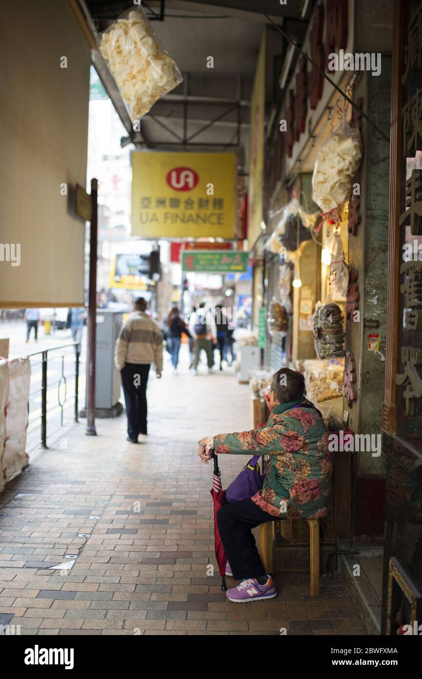 Daily life on the streets of Hong Kong with people walking and shopping during a sunny day. Hong Kong. Stock Photo