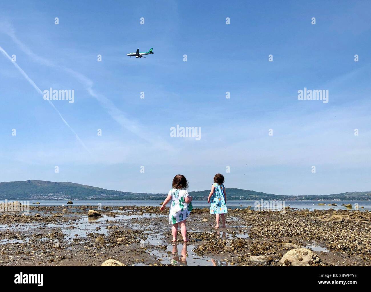 People enjoy the warm weather at seapark beach in holywood hires stock