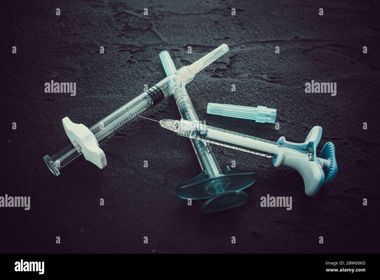cosmetology injections. Plastic syringe on black background. Medical