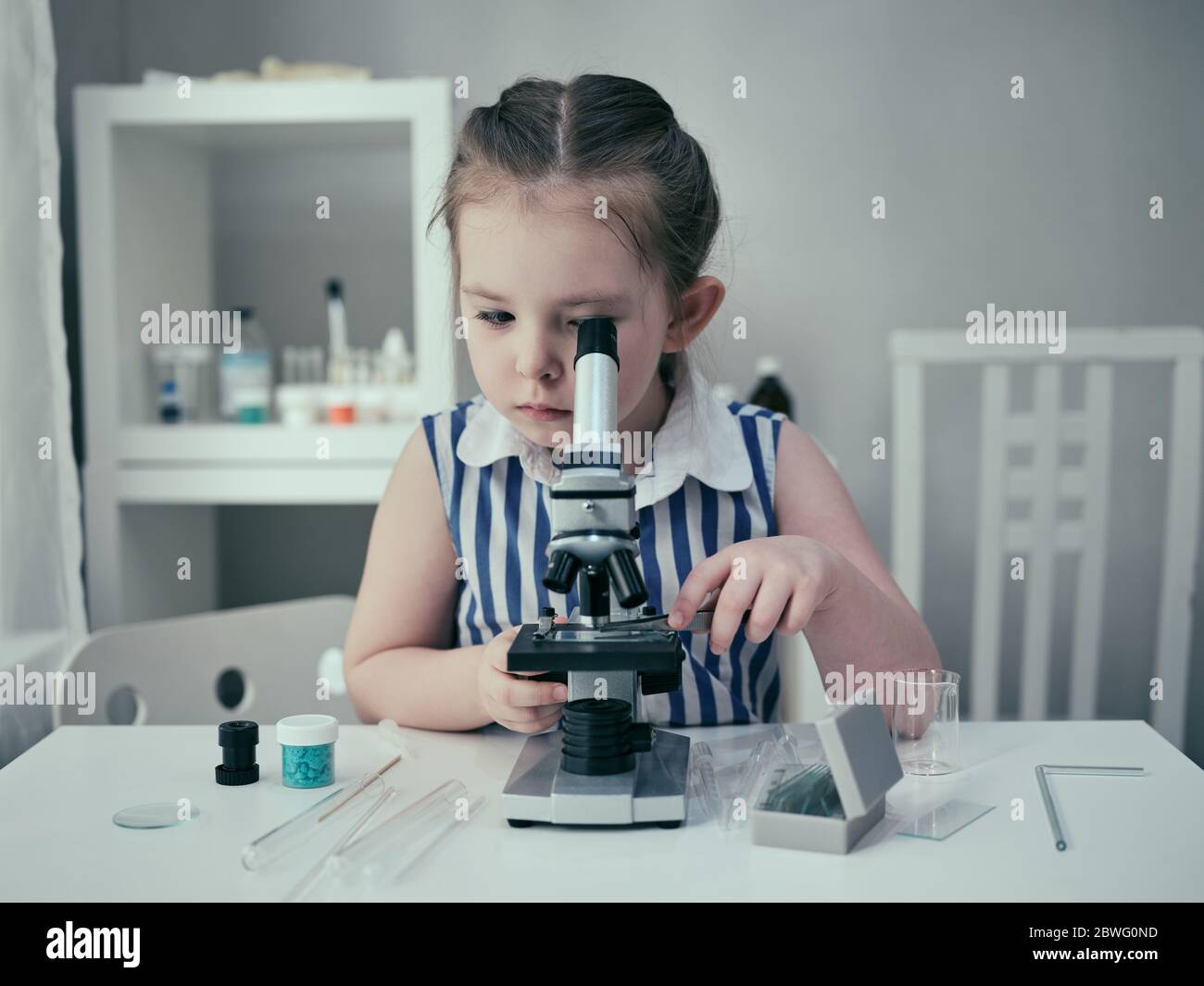 Little adorable girl makes scientific experiments with chemical and