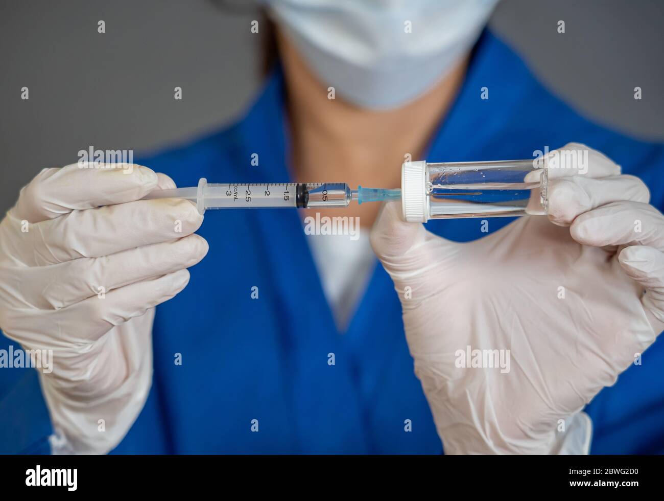 COVID-19 Coronavirus Vaccine. Doctor scientist with syringe analyzing virus Sars-CoV-2 in research for vaccine to be ready for clinical trial. Female Stock Photo