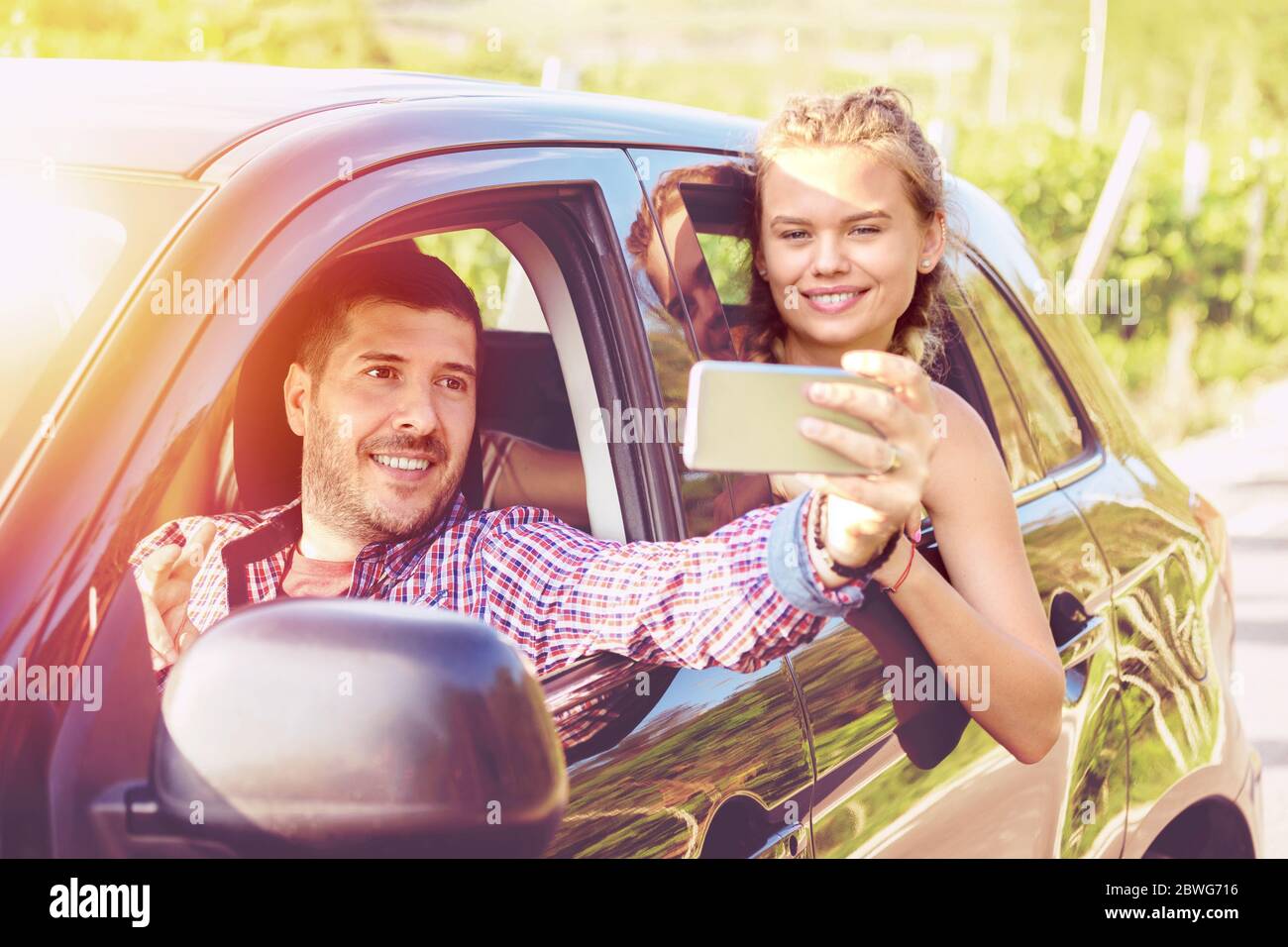 Happy young couples on road trip taking selfie while driving on ...