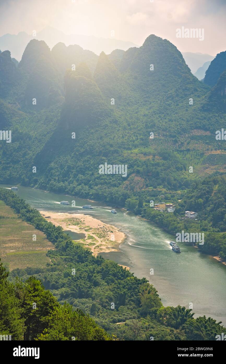 Shot of a Li river meandering through the beautiful green, lush and dense karst mountain landscape in Yangshuo, as seen from Xianggong Hill viewpoint, Stock Photo