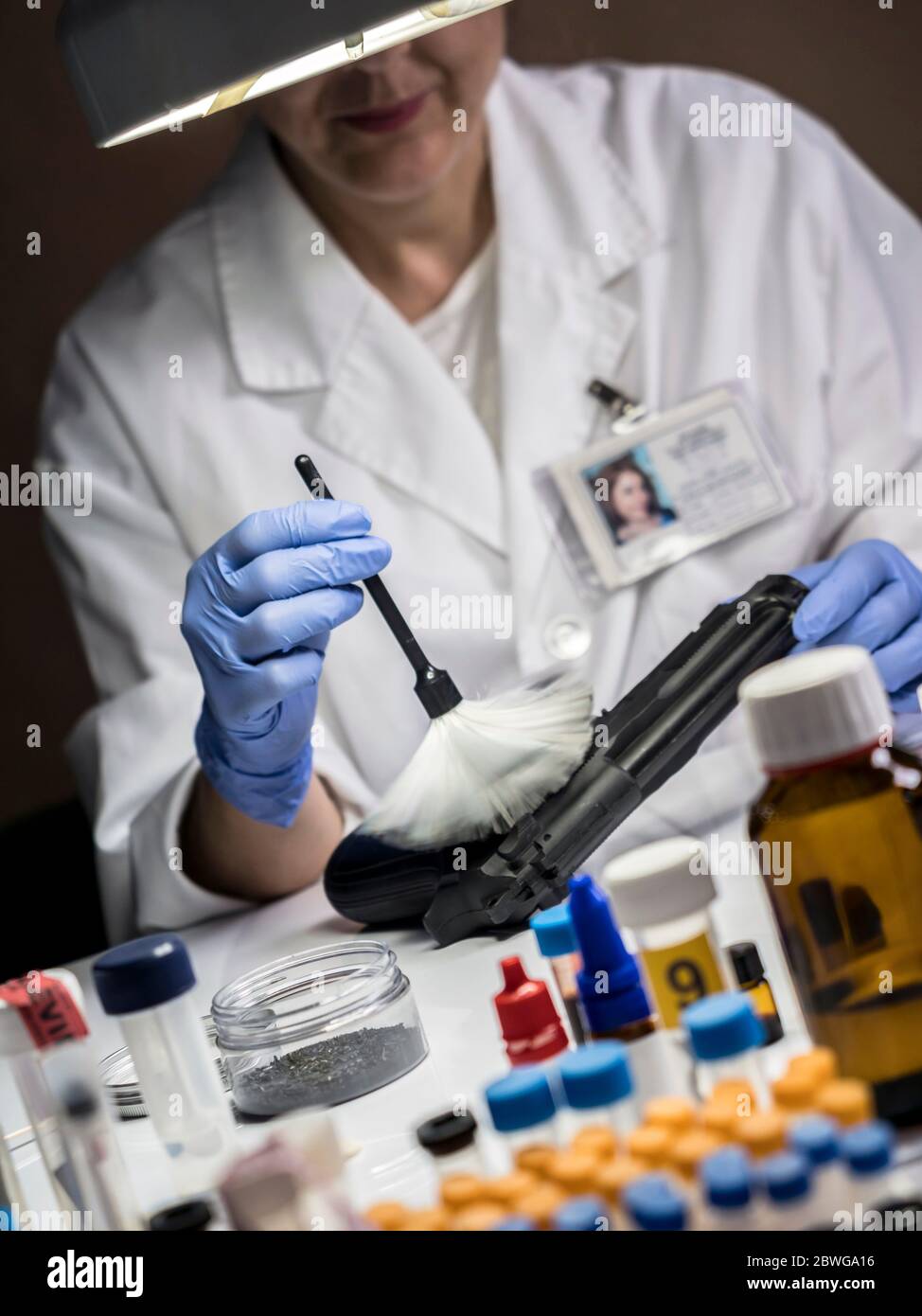 Scientific police officer analyzes gun to find traces, conceptual image Stock Photo