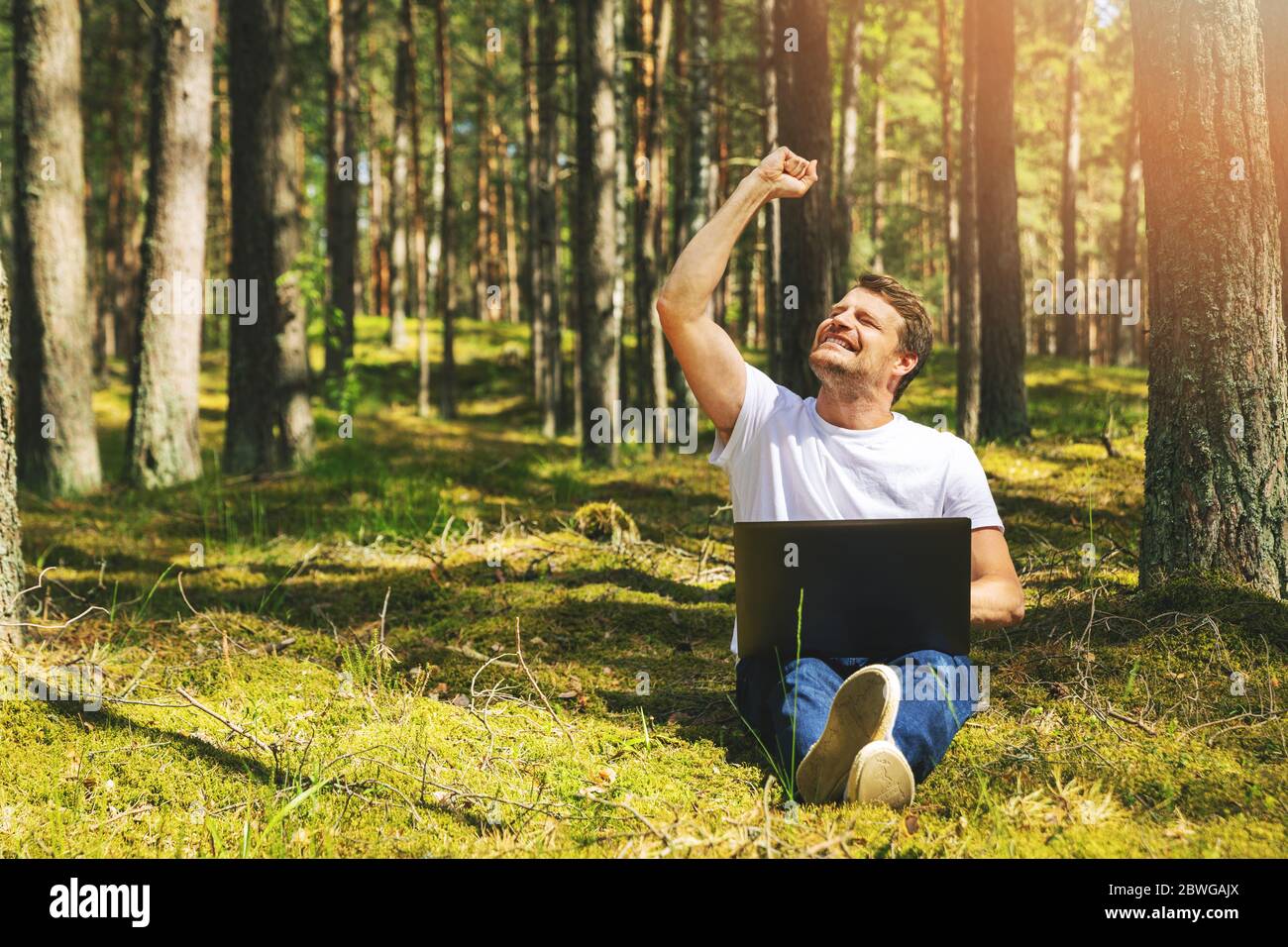 cheerful freelancer with hand raised working outdoors Stock Photo