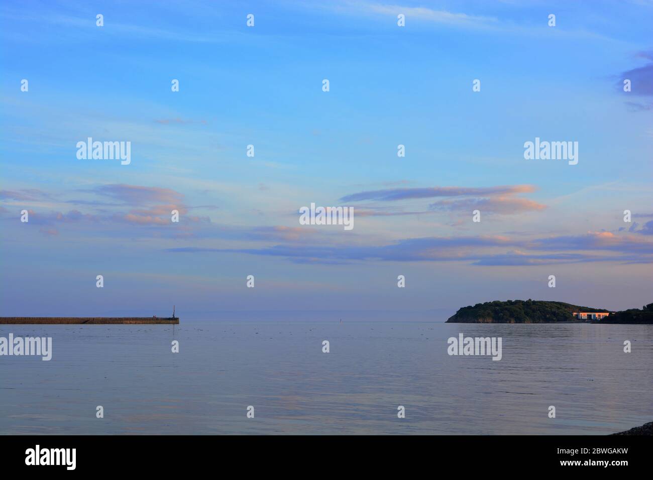 Barry, Wales, The causeway and point at Barry Island on the horizon. High tide with the sun