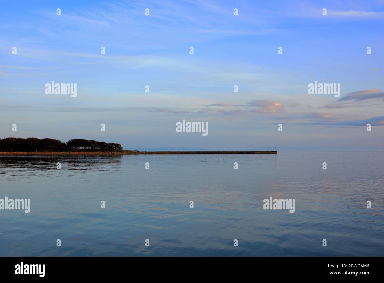 Barry, Wales, The causeway and point at Barry Island on the horizon. High tide with the sun