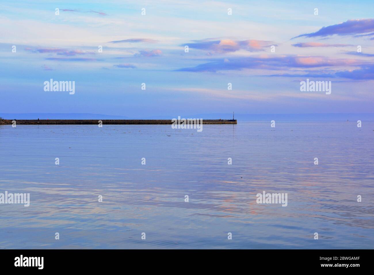 Barry, Wales, The causeway and point at Barry Island on the horizon. High tide with the sun