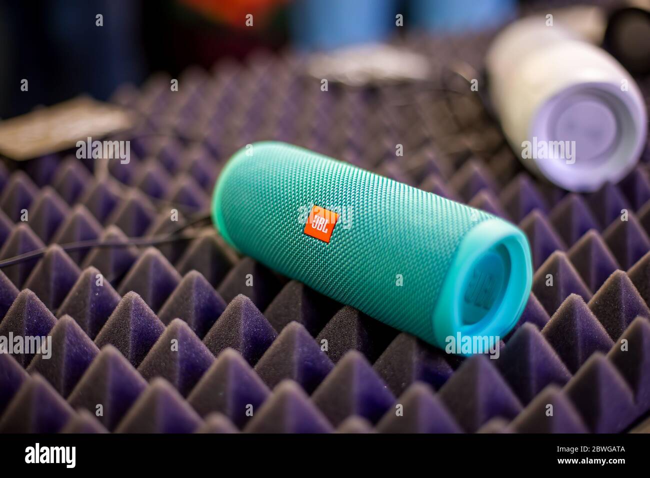Moscow, Russia - October 04, 2019: close up of blue portable waterproof bluetooth music speaker JBL Charge 4 rests on noise reduction cover. soft Stock Photo
