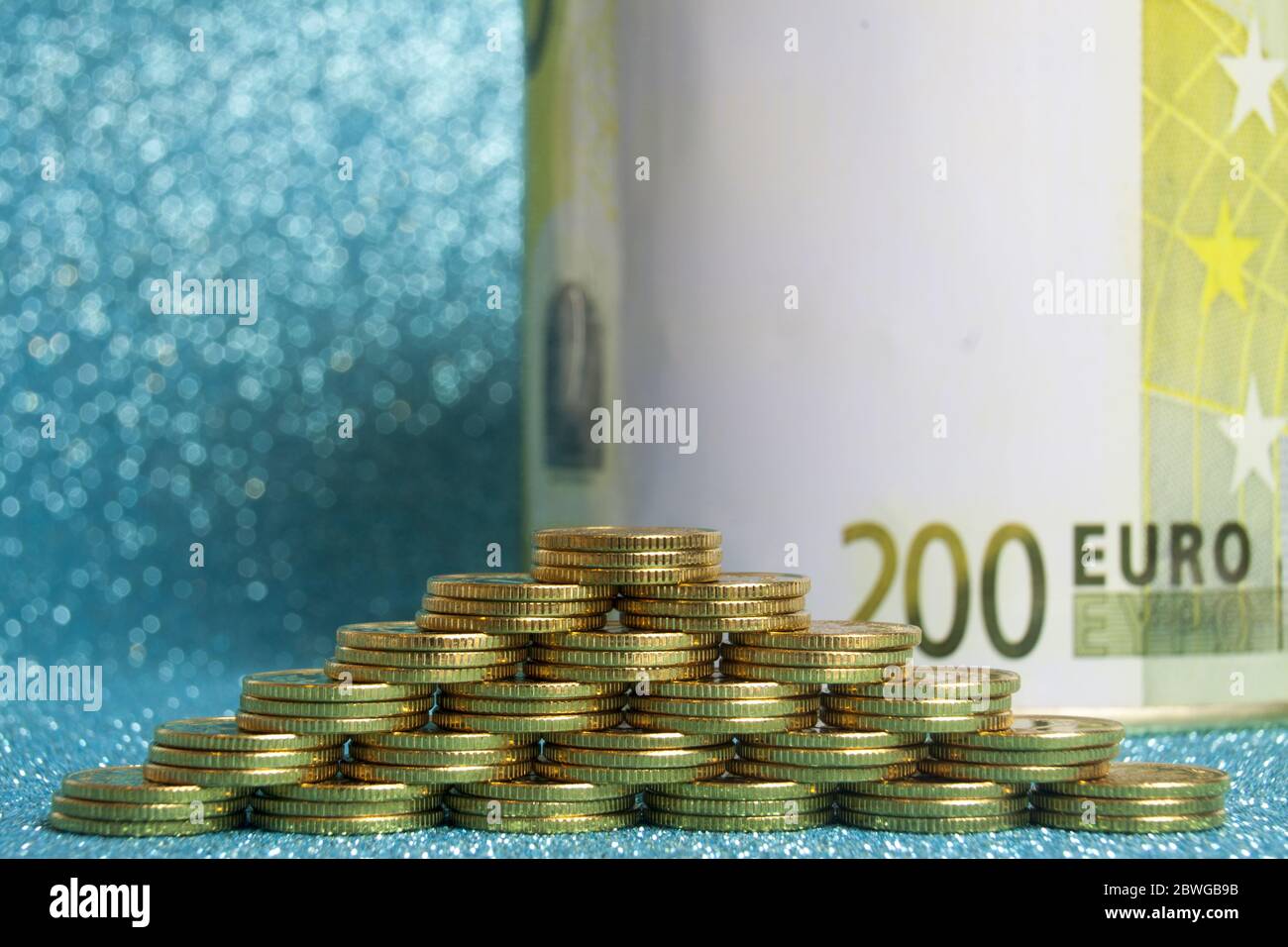 Pyramid of stacks of gold coins on a blue background and the sign of ...