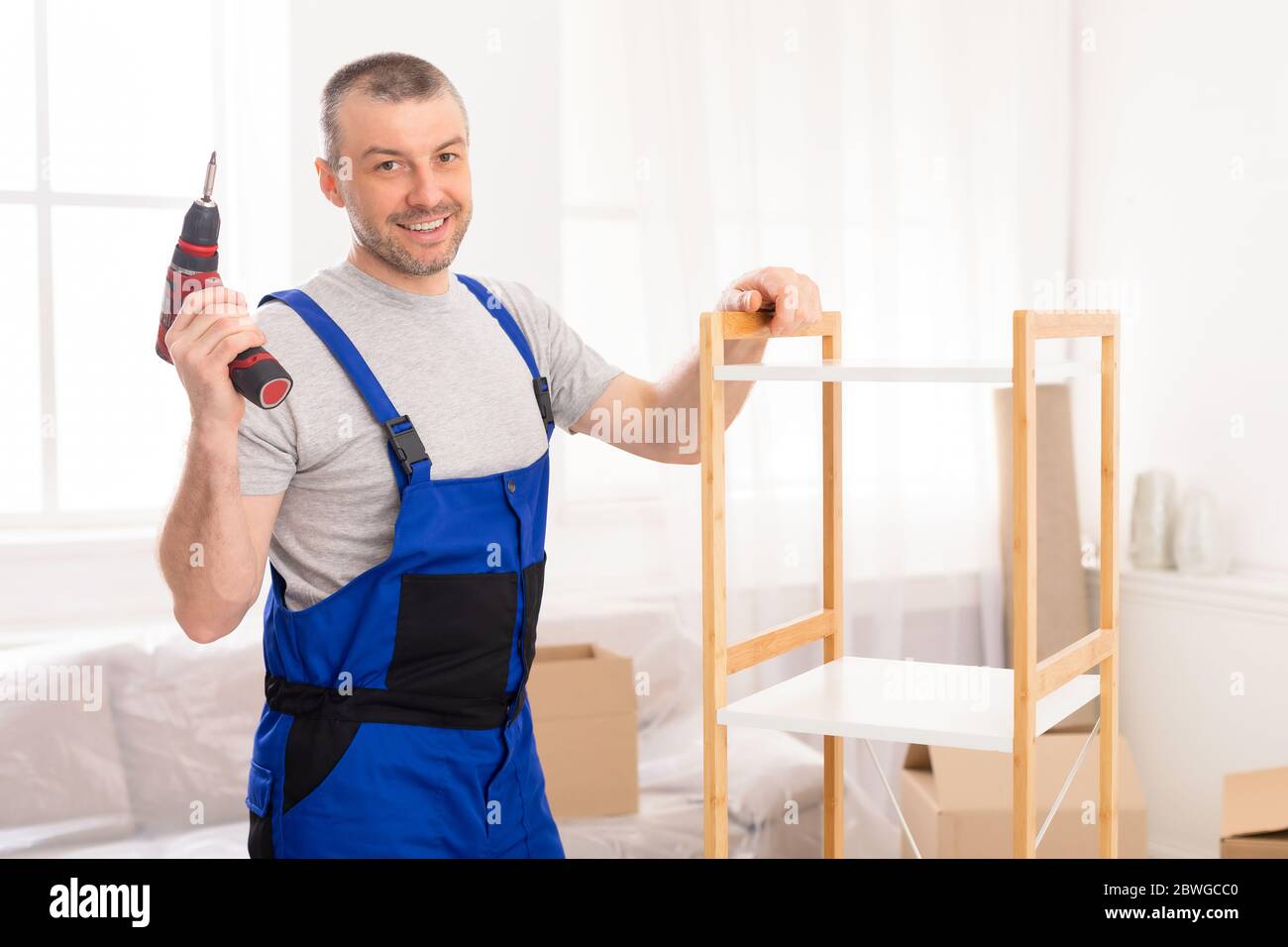 Furniture Assembler Posing With Electric Drill Assembling Indoor Stock Photo Alamy