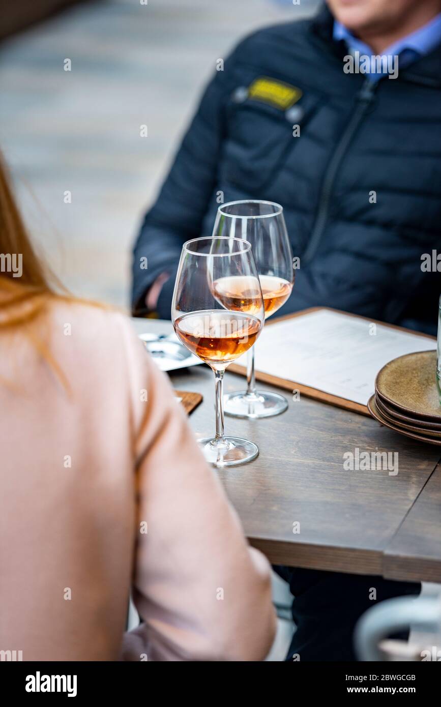 A couple sitting drinking wine at a trend wine bar restaurant at Battersea power station Stock Photo