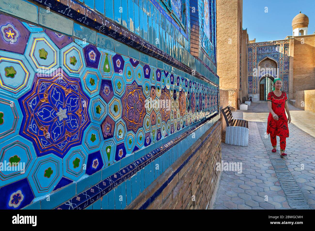 Woman in local dress walking in the courtyard of the Holy Cemetery of Shah-i-Zinda, in Samarkand, Uzbekistan. Stock Photo