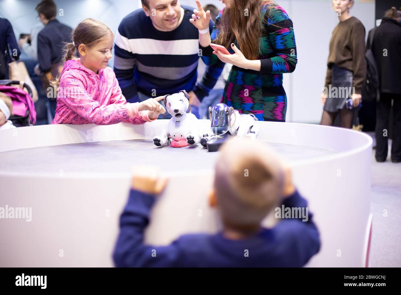 Moscow, Russia - October 04, 2019: child girl plays with Aibo Robotic pets designed and manufactured by Sony Pet robot Technology lifestyle with Stock Photo
