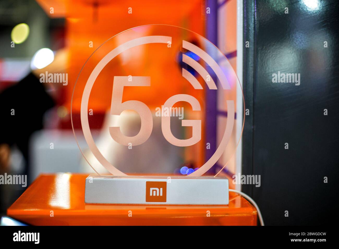 Moscow, Russia - October 04, 2019: 5g white icon xiaomi on transparent plastics. Orange background in blur. close up, front view. Stock Photo