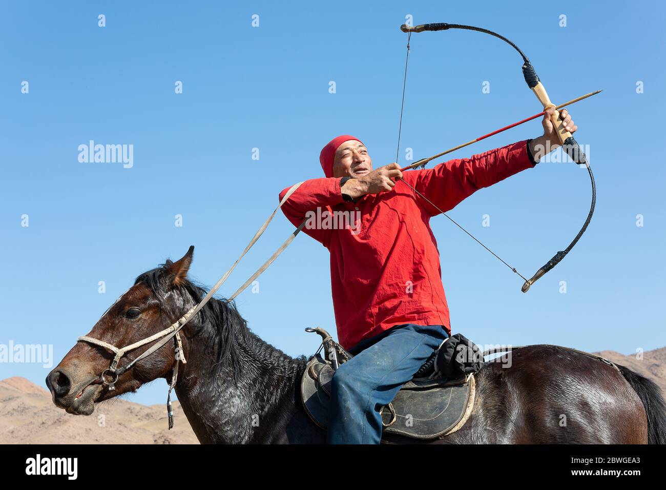 Kyrgyz nomadic man doing archery, in Issyk Kul, Kyrgyzstan Stock Photo