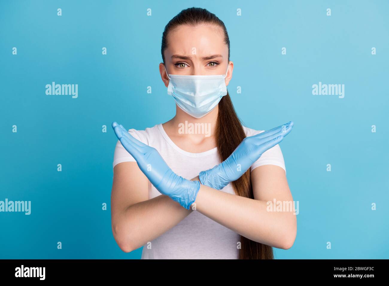 Photo of pretty serious lady crossing arms keep social distance avoid people crowd contact hospital examination wear protect face mask t-shirt Stock Photo