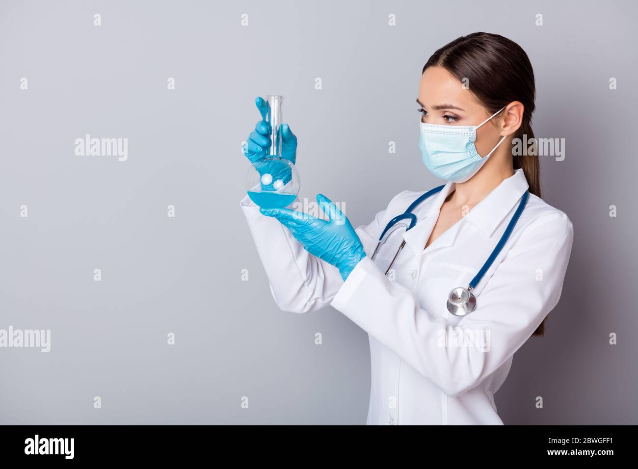 Photo of serious virologist doc lady experienced professional hold glass test flask tube