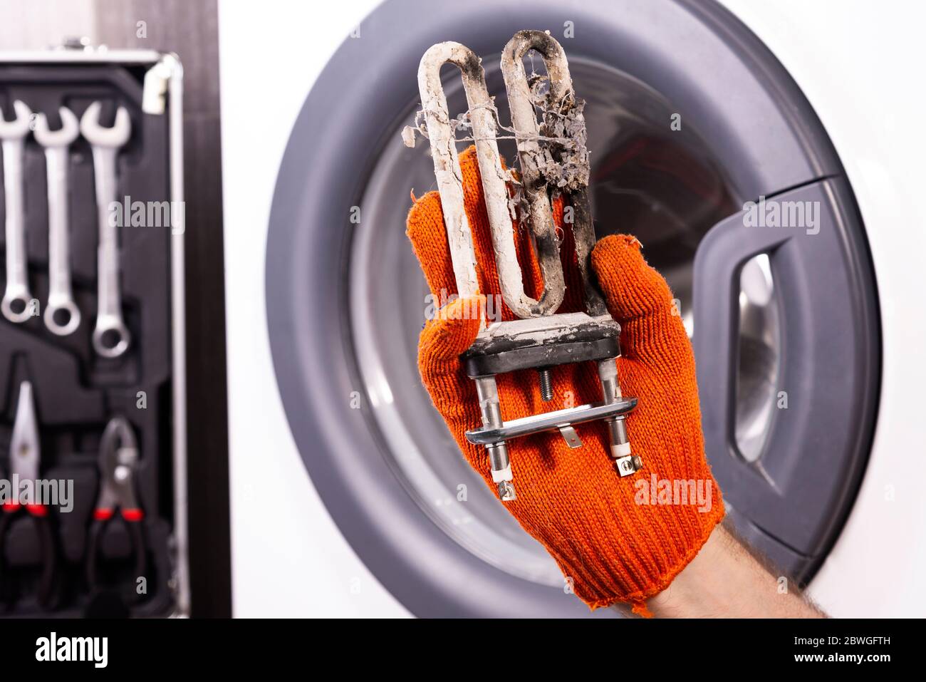 Repair of washing machines. Hand of a repairman with a turbulent