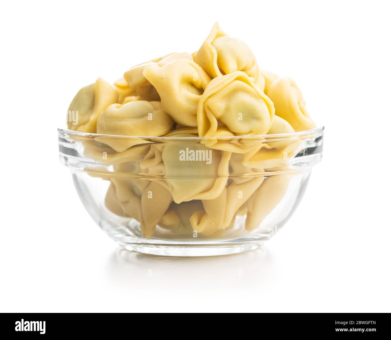 Tortellini pasta in glass bowl. Italian stuffed pasta isolated on white