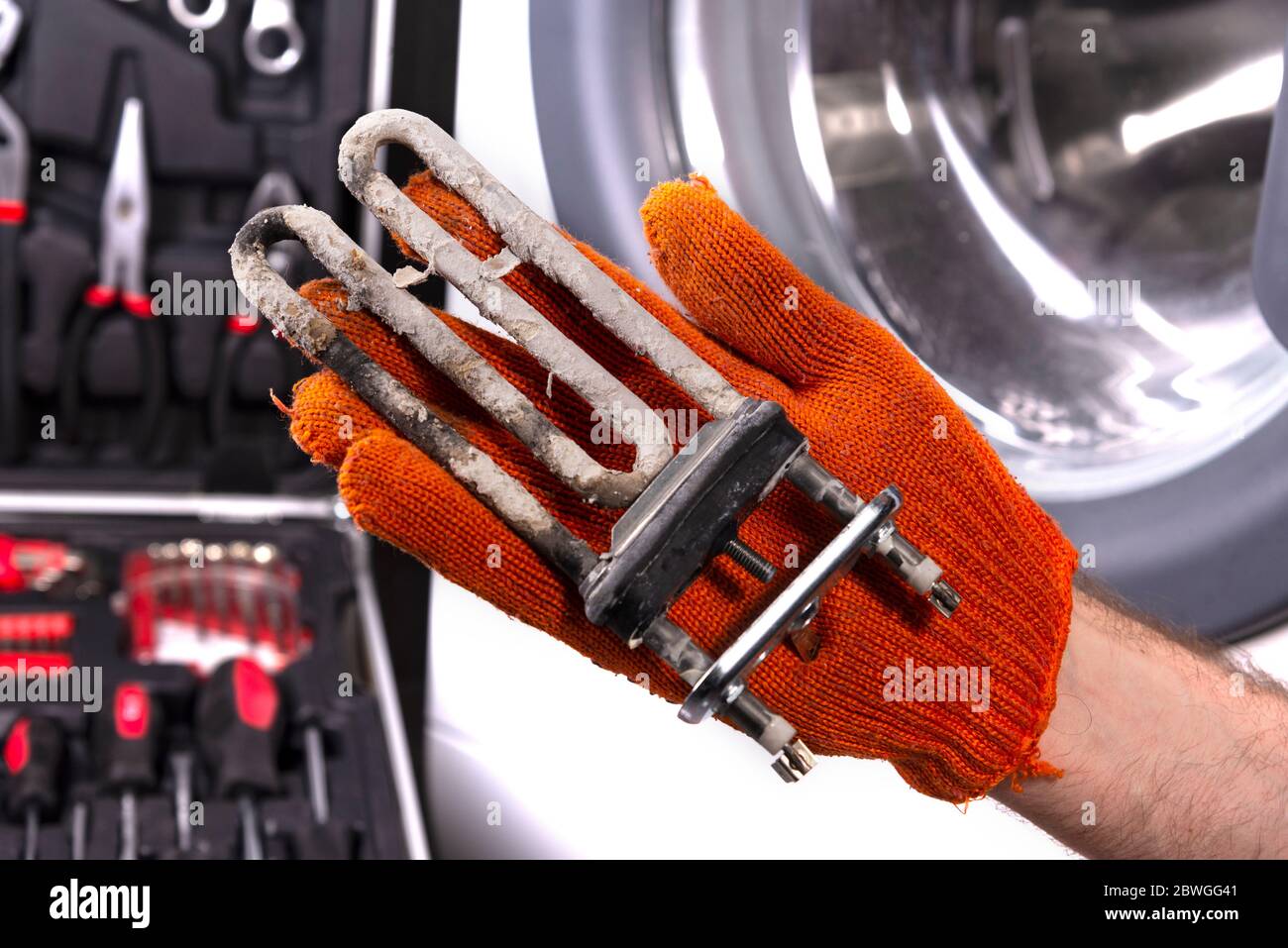 Repair of washing machines. Hand of a repairman with a turbulent