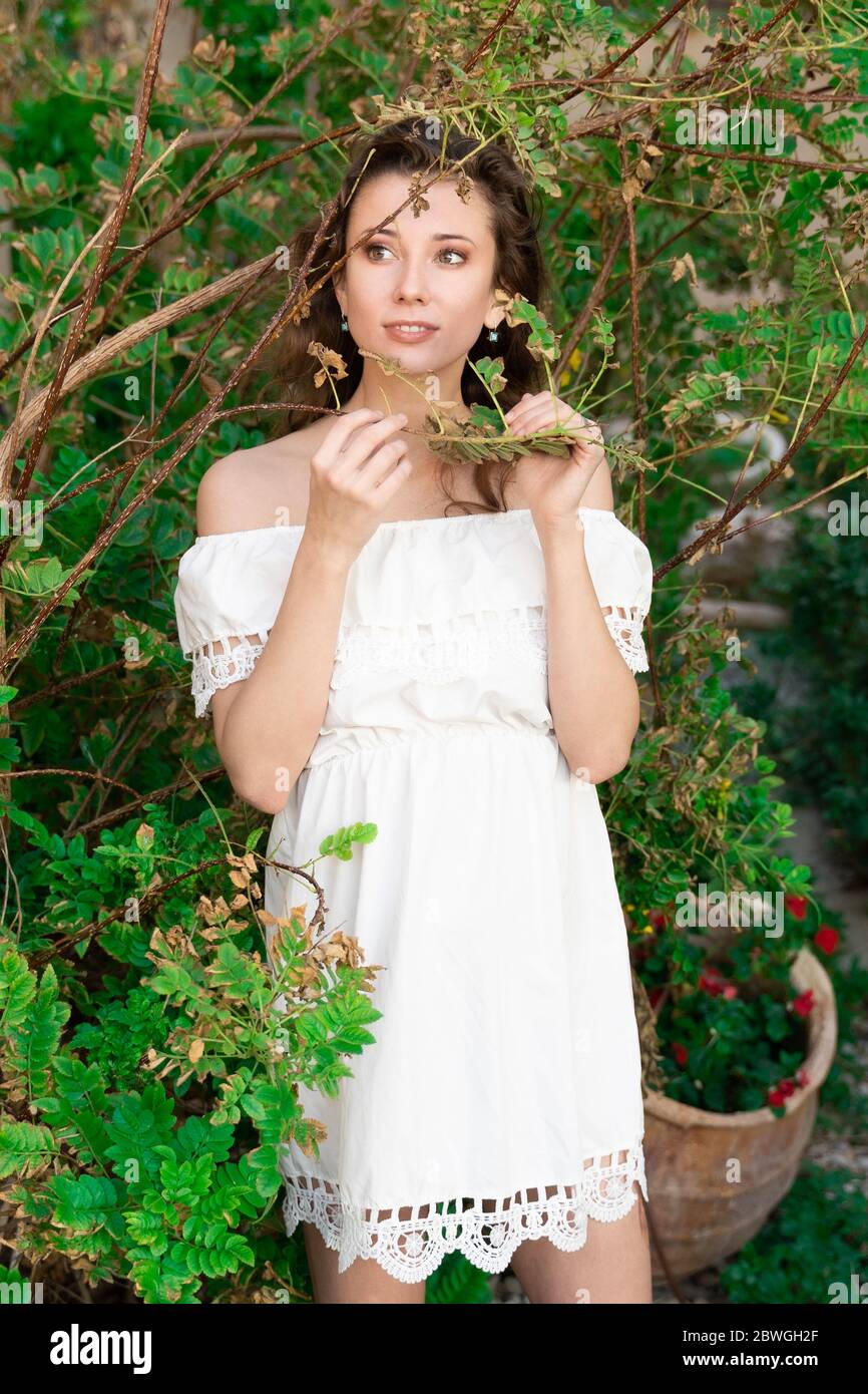 Summer beautiful girl in a white dress between green plants Stock Photo ...