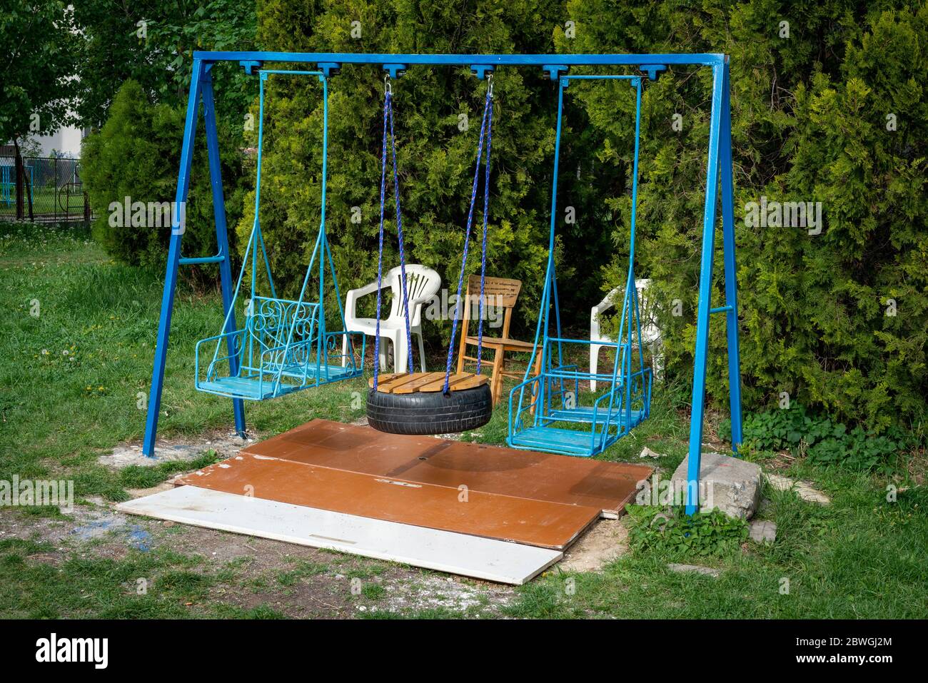 Empty metal swings and chairs at playground and picnic area in urban environment, Sofia, Bulgaria, Eastern Europe, EU Stock Photo