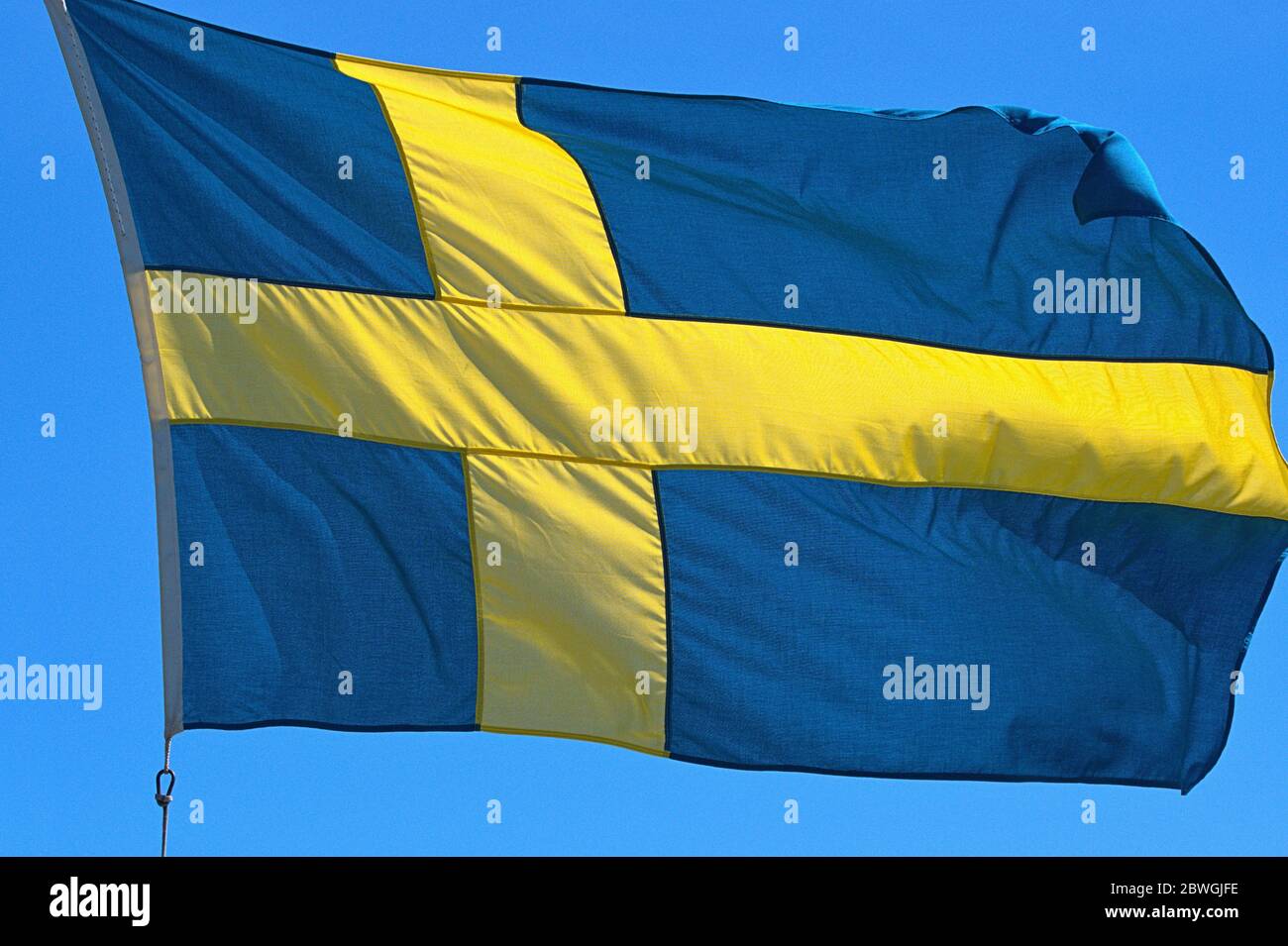 Schleswig, Deutschland. 01st June, 2020. 01.06.2020, Schleswig, the Swedish flag with the yellow Scandinavian cross on a blue background, illuminated by the sun against a blue sky and blowing in the wind. | usage worldwide Credit: dpa/Alamy Live News Stock Photo
