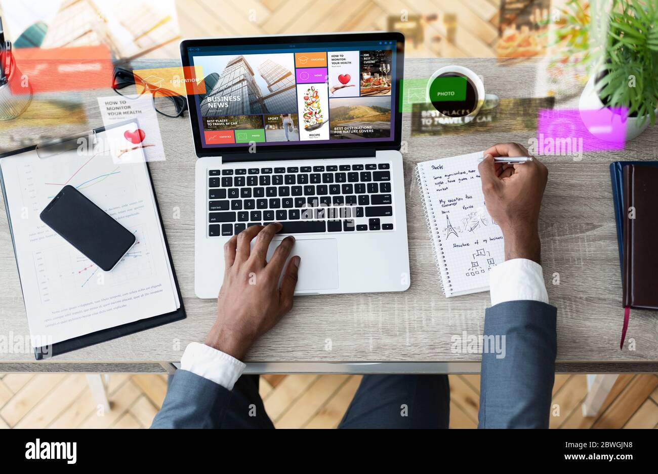 Top view of businessman with laptop making notes while searching 