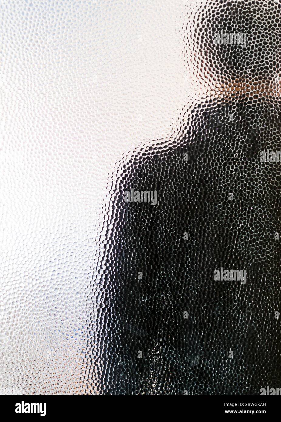Man in black behind closed door through glass Stock Photo