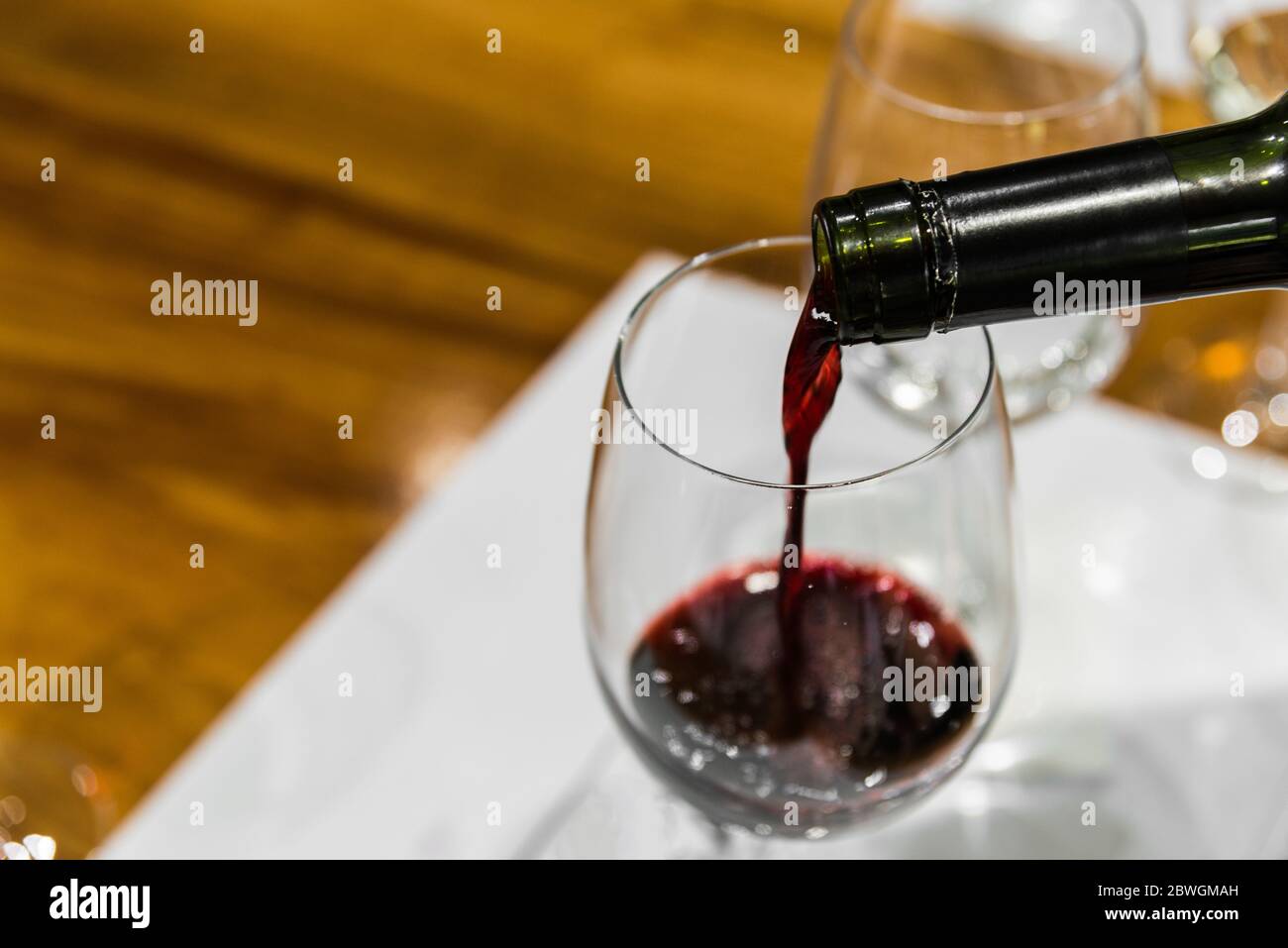 A sommelier serving red wine into a wine glass Stock Photo Alamy