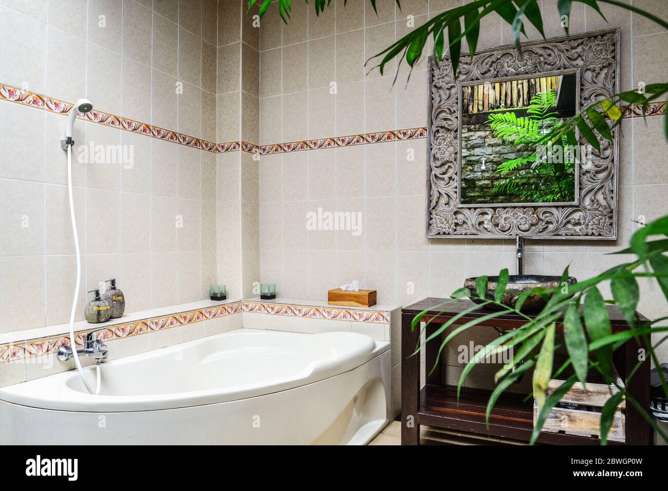 Bathroom with washbasin, mirror and bath in traditional balinese style ...