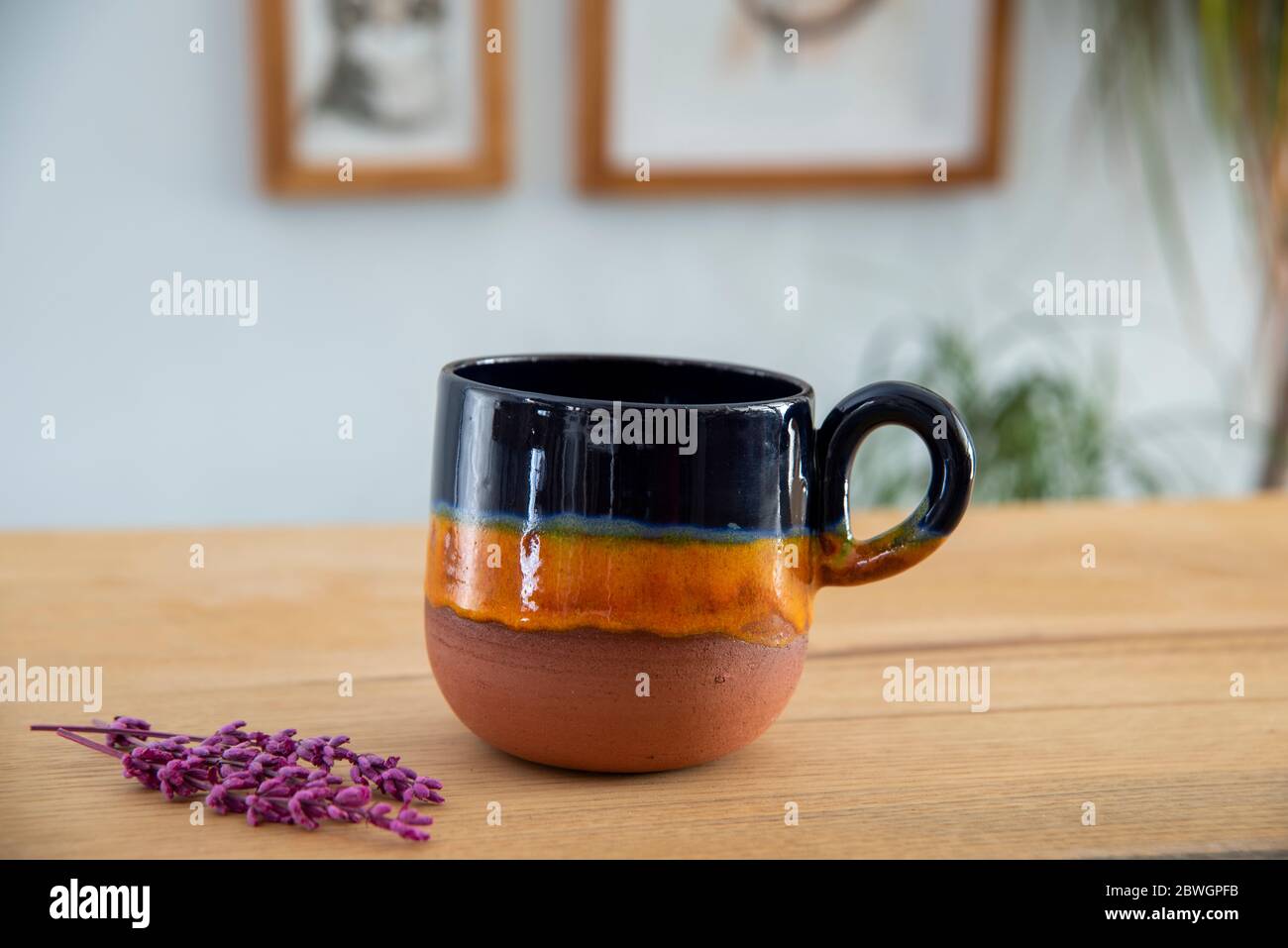 https://c8.alamy.com/comp/2BWGPFB/colorful-handmade-ceramic-coffee-cup-on-wooden-table-2BWGPFB.jpg
