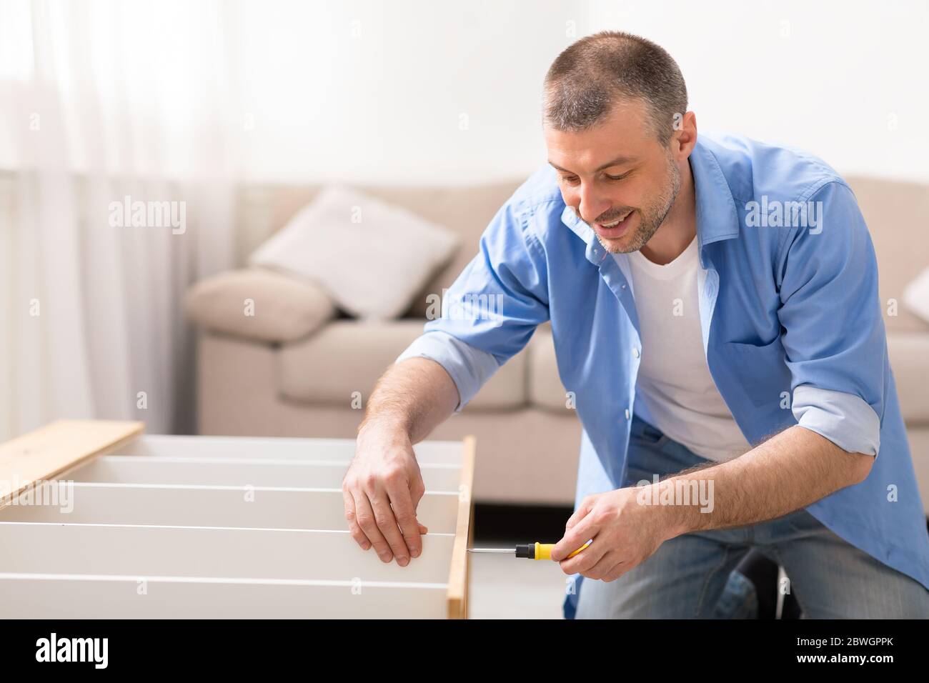 Man Assembling Furniture Installing Shelf Making Renovation At Home