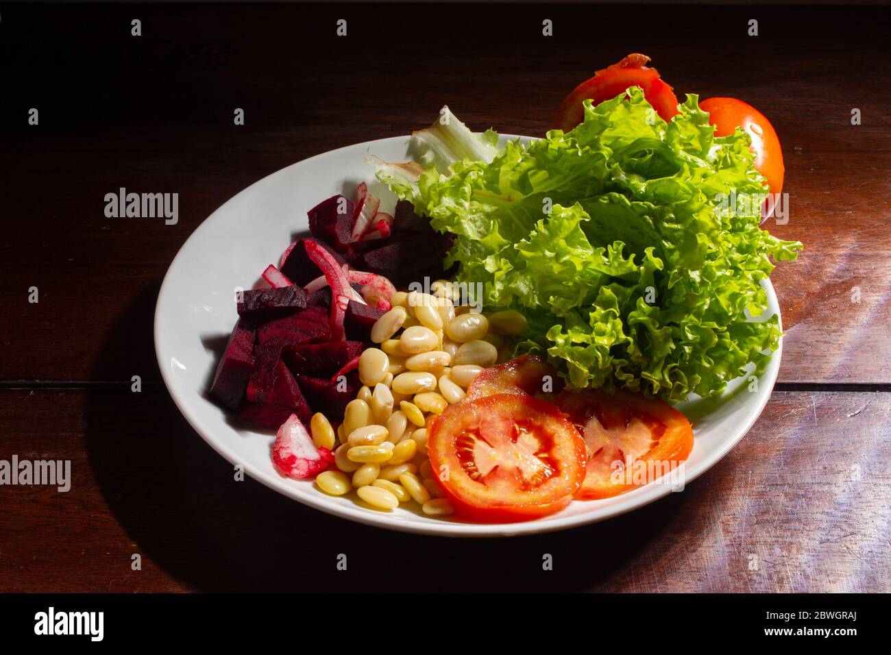 Vegan food. Plate of lettuce, beet, fava and tomato. Stock Photo