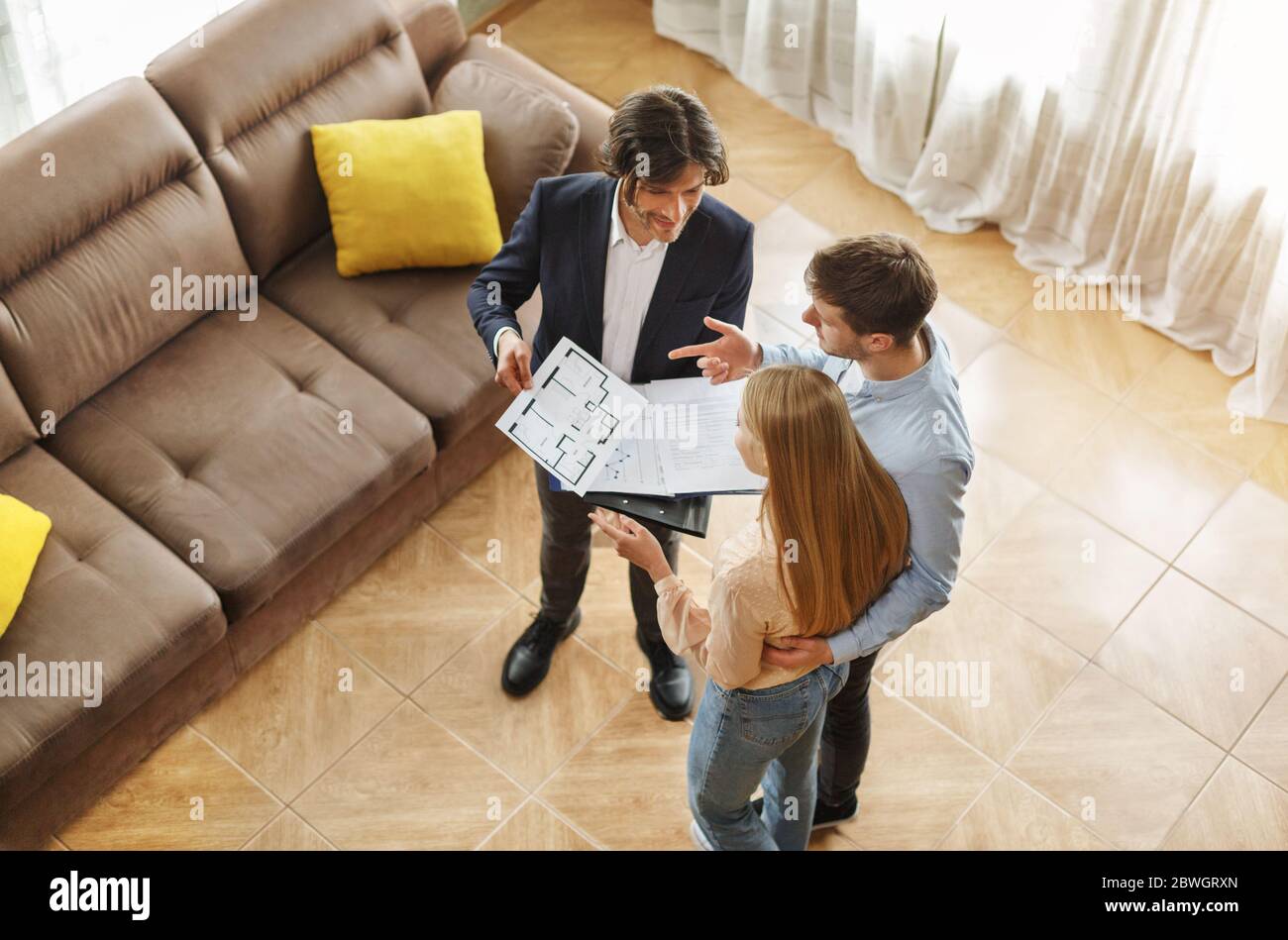 Above view of real estate agent communicating with customers about house purchase or rent indoor Stock Photo