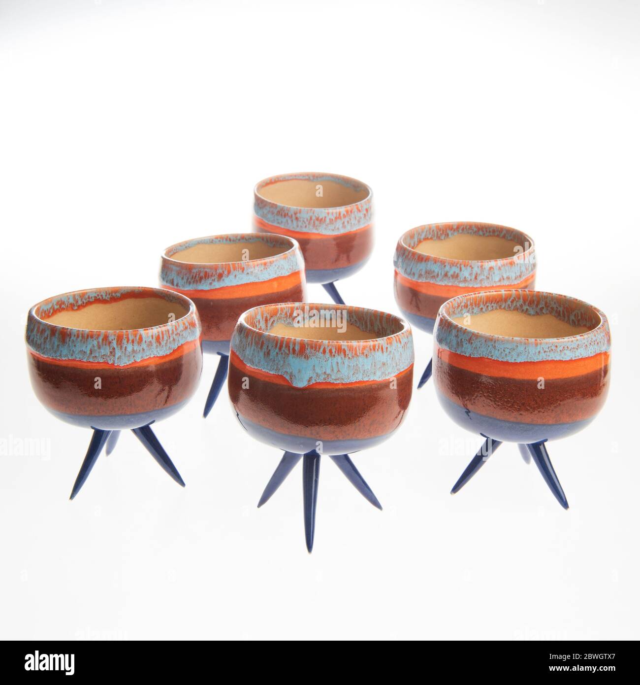 cactus in colorful handmade ceramic pot on white table Stock Photo