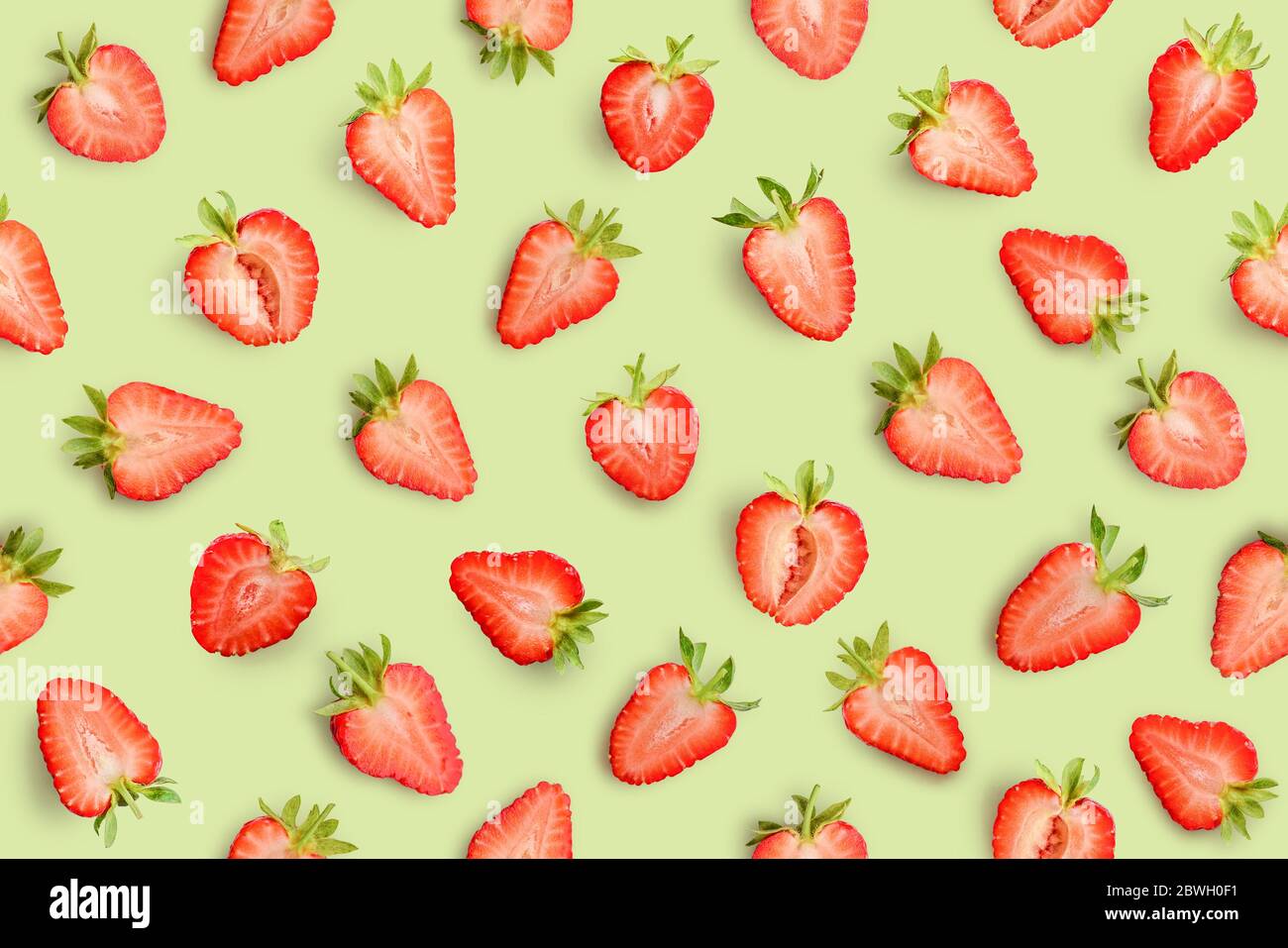 Strawberry slices as seamless pattern on green background Stock Photo