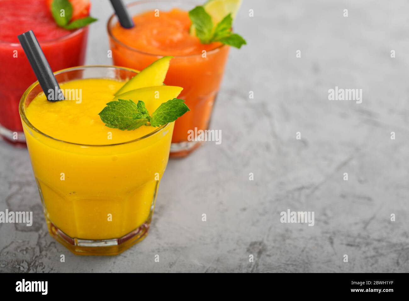 Fresh Strawberry Mango And Papaya Smoothies In Glasses On Grey Background Stock Photo Alamy