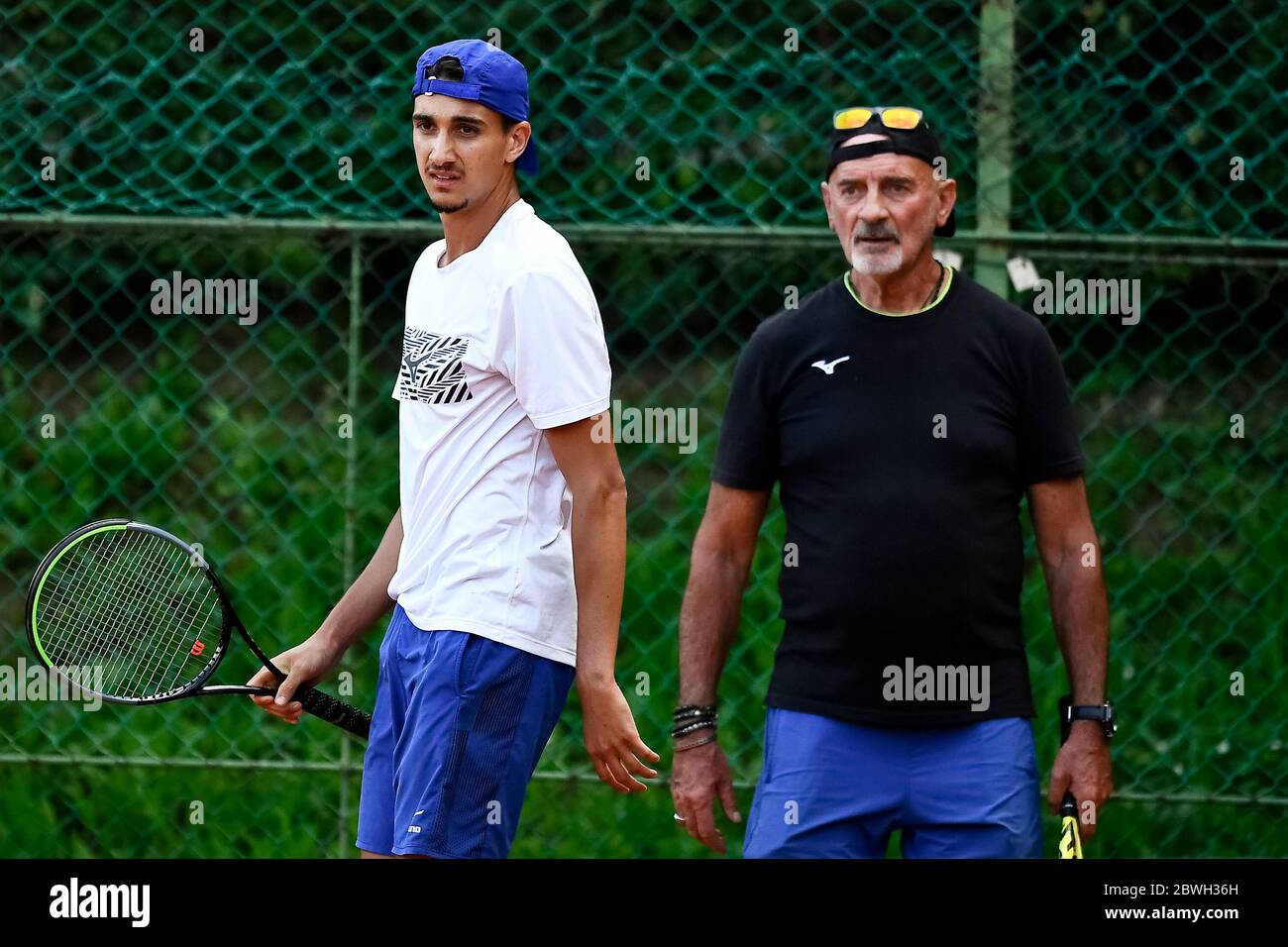 Turin, Italy - 01 June, 2020: Lorenzo Sonego (L), currently number 46 of ATP  ranking, and his coach Gipo Arbino look on during a tennis training.  Athletes have started training again after