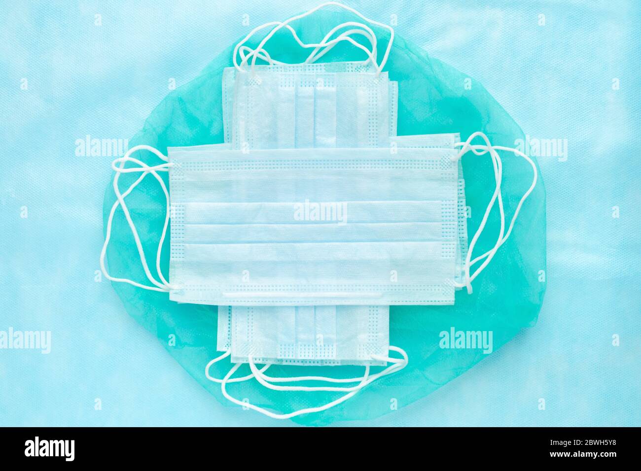 Lot medical surgical face masks on green and blue background. World