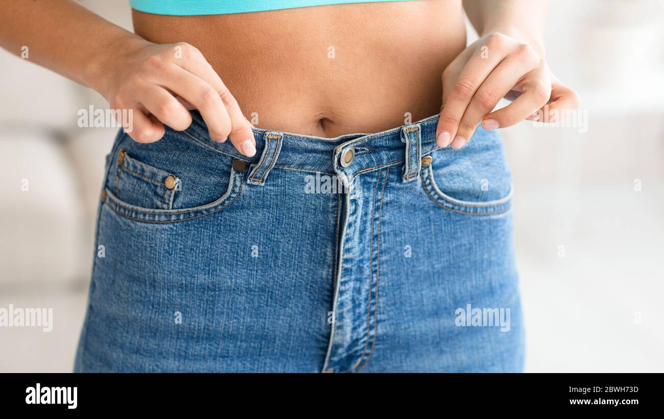 Unrecognizable Skinny Girl Showing Too-Big Jeans Posing Indoors, Cropped, Panorama Stock Photo