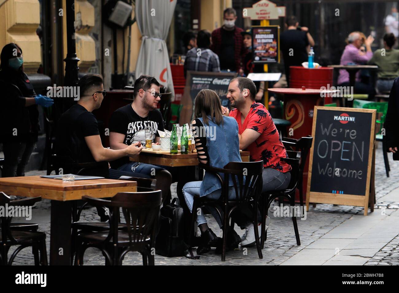 Bucharest, Romania. 1st June, 2020. People enjoy drinks on the reopened terrace of a restaurant in Bucharest, Romania, on June 1, 2020. Romania adopted new relaxation measures from June 1, including reopening open-air terraces of restaurants and beaches, lifting the travel restrictions for residents, as well as allowing outdoor shows and sports events. Credit: Cristian Cristel/Xinhua/Alamy Live News Stock Photo
