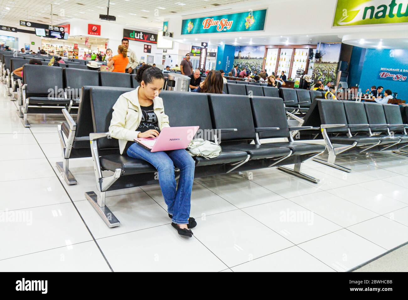 Mexico City,México Mexican,Benito Juarez International Airport,Terminal 1,MEX,gate,waiting,seats,Hispanic adult,adults,woman female women,laptop,noteb Stock Photo